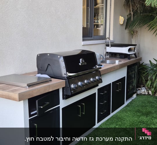 מטבח חוץ עם גריל גז, כיור ומשטח עבודה